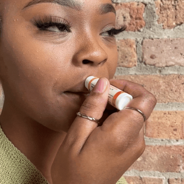 woman applying tallow lip balm